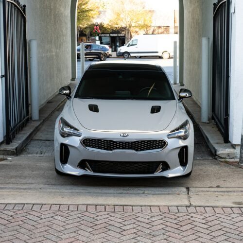 Kia Stinger in a colorful alley in Marietta Square photographed from the front.