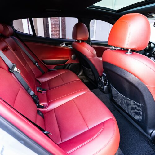 Kia Stinger photographed from the passenger side showing the interior and the rear seat.