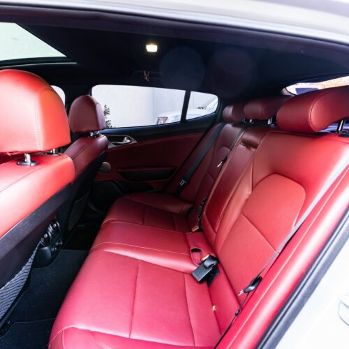 Kia Stinger photographed from the driver side showing the interior and the rear seat.