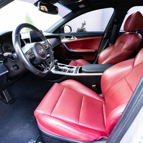 Kia Stinger photographed from the driver side showing the interior and the front seat.