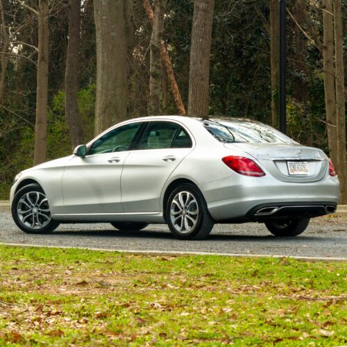 Mercedes C-Class parked in a lot photographed from the driver side rear quarter panel.