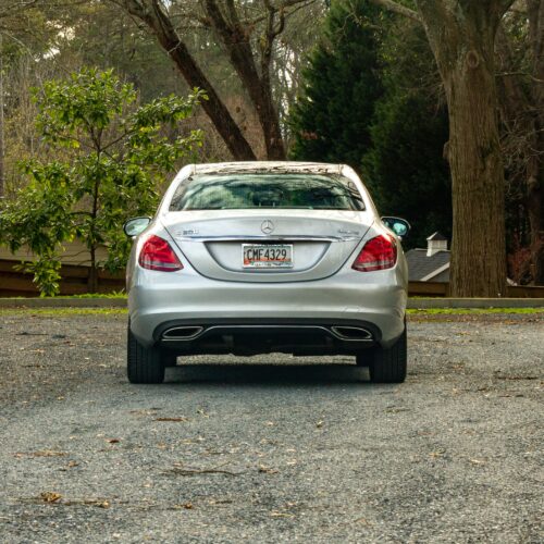 Mercedes C-Class parked in a lot photographed from the rear.