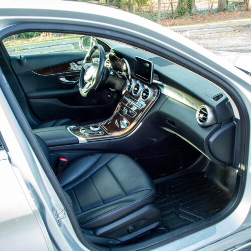 Mercedes C-Class parked in a lot photographed from the passenger side showing the interior and the front seat.